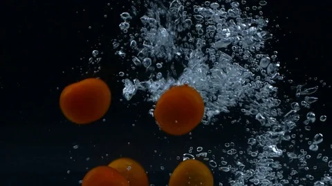 Slow motion of red cherry tomatoes falling down and splashing in water Stock Footage 123348103