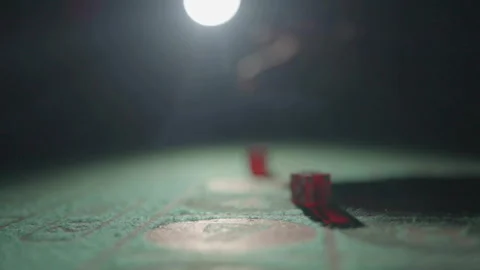 Slow motion red dice thrown toward camera on table Stock Footage 335699937