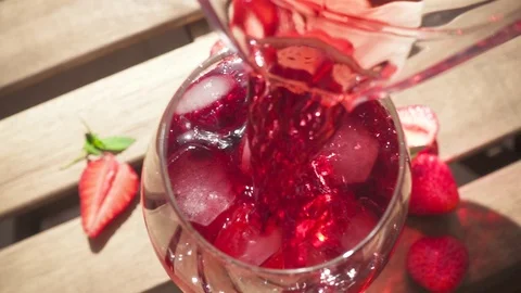 Slow motion red drink pours into a glass on the table Stock-Footage 90419020