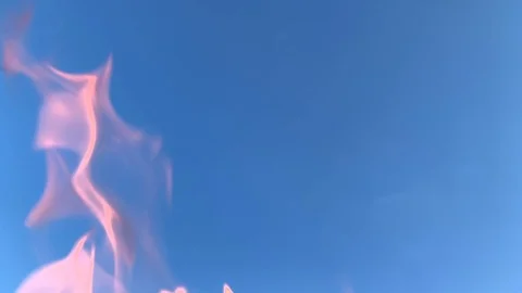 Slow motion of red fire background against the blue clear sky. Stock Footage