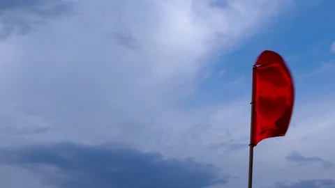 Slow motion of Red flag moving in wind. Blue cloudy sky background Stock Footage 91106381