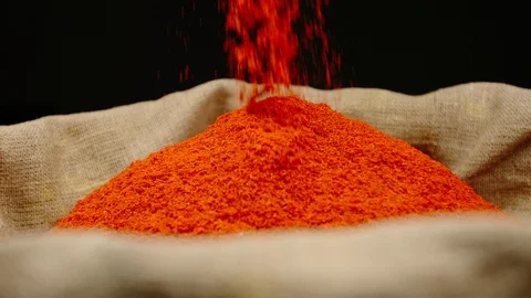 SLOW MOTION: Red pepper powder falls in a sac Stock Footage 121942684