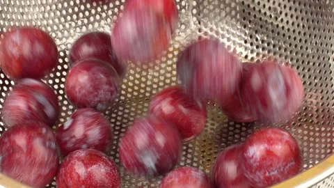 Slow Motion Red Plums Falling and Washing in Stainless Steel Colander Stock Footage 319916551