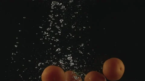Slow-motion of Red Small Cherry Tomatoes falling into the Water Stock Footage 171478937