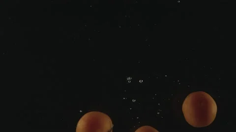 Slow-motion of Red Small Cherry Tomatoes falling into the Water. Stock Footage 171515549