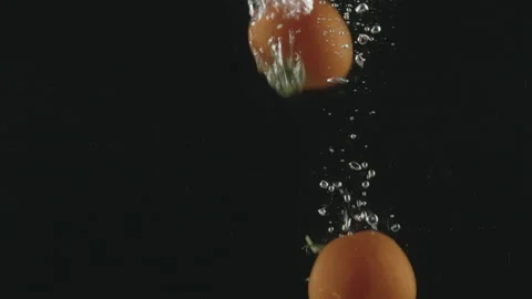 Slow-motion of Red Small Cherry Tomatoes falling into the Water. Stock Footage 171520014