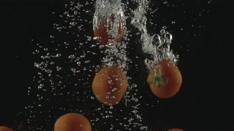 Slow-motion of Red Small Cherry Tomatoes falling into the Water. Stock Footage 171543363