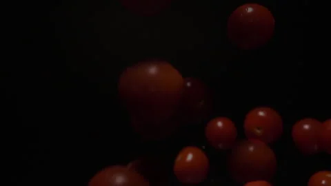 Slow motion of red small cherry tomatoes falling into water Stock Footage 252406209