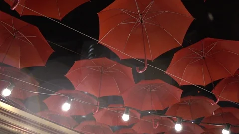 Slow motion red suspended umbrellas at night in the rain Stock Footage 116391654