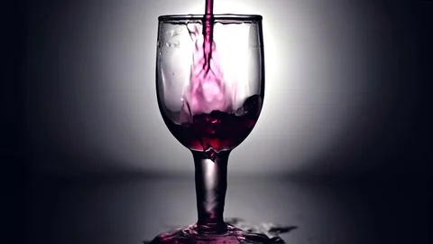 Slow motion of red wine being poured on crystal glass globlet Stock Footage 76816014