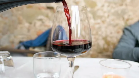 Slow motion of a red wine glass puoring in a restaurant. Italian red wine taste Stock Footage 345247055
