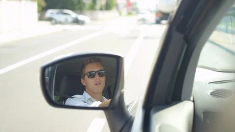 SLOW MOTION: Reflection of an angry driver in the side mirror of his new car. Stock Footage 95672654