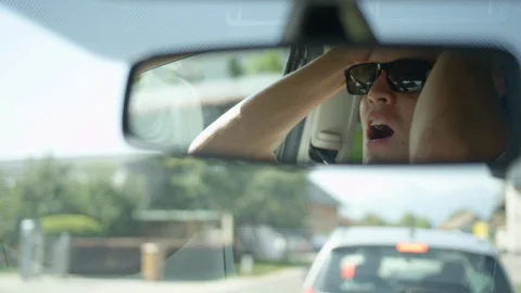 SLOW MOTION: Reflection of frustrated young man yelling at car in front of him. Stock Footage 95672291