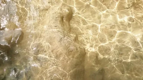 Slow motion of the reflection of sunlight on a shallow riverbed Stock Footage 321321669