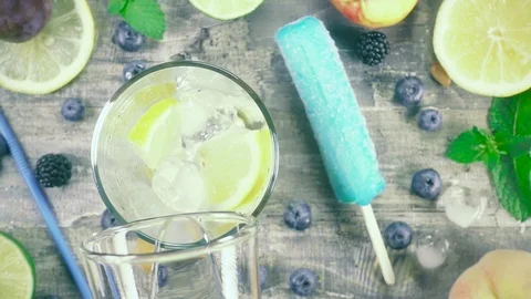 Slow motion refreshment drink with ice in a glass top view Stock Footage 93240670