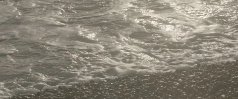 Slow Motion Right to Left Pan of Waves Crashing on Shingle Beach Stock-Footage 320114816