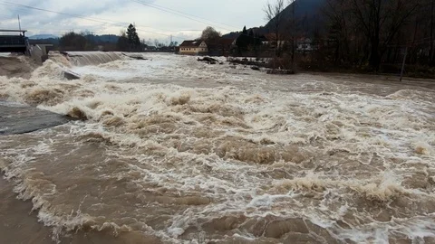Slow motion right pan close up wide raging flooded river after season rain Stock Footage 121929479