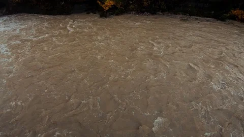 Slow motion right pan looking down over flooded river Stock Footage 120391955