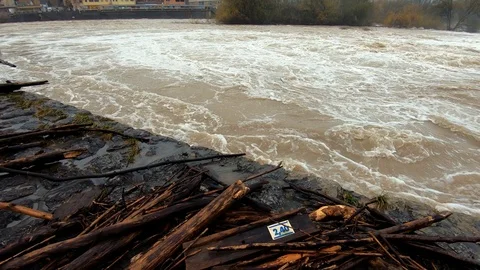 Slow motion right pan low angle dirty brown chaotic flooded river Stock Footage 120749181