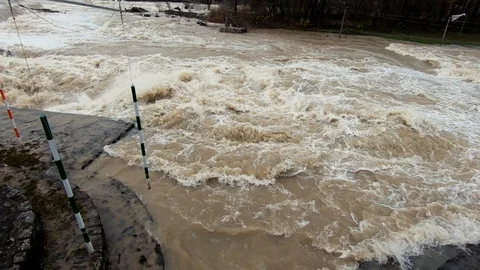 Slow motion right parallax raging brown flooded water in Tacen whitewater Course Stockbeeldmateriaal 121929563