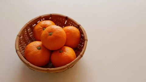 Slow motion ripe mandarin oranges in a basket close up in Japan Video stock 348197764