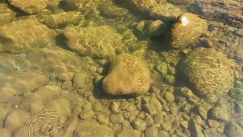 Slow motion ripples on the surface of a clear river with the sparkle Stock Footage 321860030
