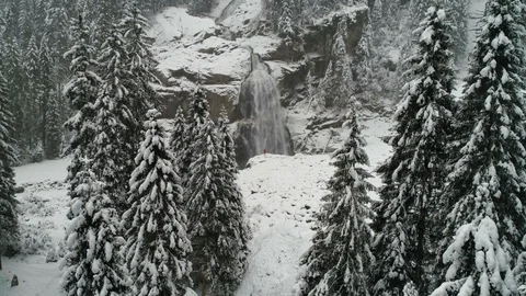 Slow motion rise through trees with person in front of waterfalls Stock Footage 102422628