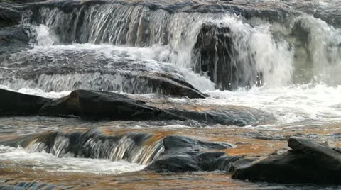 Slow motion river flowing around rocks Stock Footage 20504866