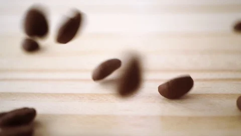 Slow motion of roasted coffee bean drop on light brown wooden texture Stock Footage 111502668