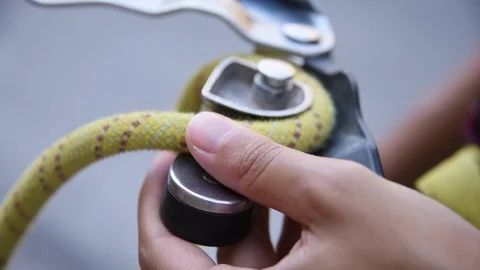 SLOW MOTION of rock climber setting up belay harness for rappelling Stock Footage 74418227
