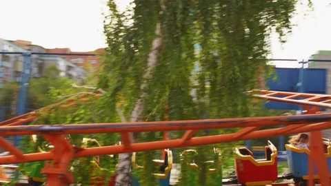 Slow motion. roller coaster. car with girls rides on rails in amusement Park Stock Footage 140426568