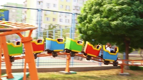 Slow motion. roller coaster. car with girls rides on rails in amusement Park Stock Footage 140531601