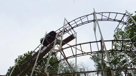 Slow motion. roller coaster. car with girls rides on rails in amusement Park Stock Footage 140532095