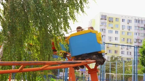 Slow motion. roller coaster. car with girls rides on rails in amusement Park Stock Footage 140612568
