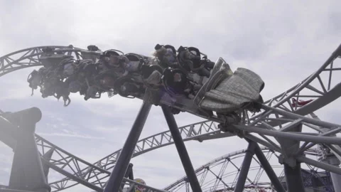 Slow motion roller coaster spiral loop in UK theme park Stock Footage 144544145