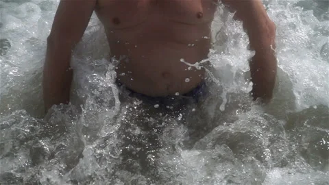 Slow motion rolling a foamy wave on a man in the water. Stock Footage 114301264