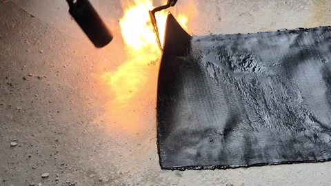 Slow motion of roofer melting bituminous membrane with flame torch Stock Footage 345666553