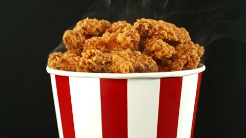 Slow Motion of Rotating Fried Chicken Pieces in Bucket on Colored Background Stock Footage 304506304