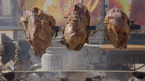 Slow motion rotating pieces of meat roasted over flame Stock Footage 254518943
