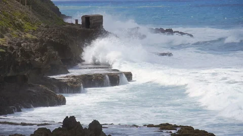 Slow Motion - Rough storm seas pounding rocky shore below El Morro Castle walls Stock Footage 61431741