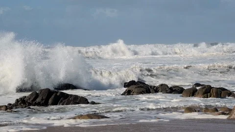 Slow motion rough, white waves breaking against rocks on beach, spray splashing Stock Footage 119293225
