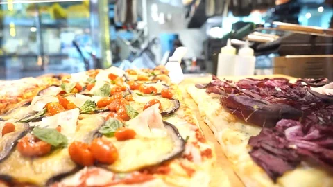 Slow-motion of a row of flatbread pizzas in the showcase table in front of th Stock Footage 129928016