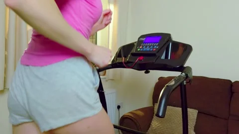 Slow motion run of unrecognizable woman jogging on treadmill during indoor home Stock Footage 339344863