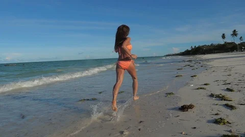 SLOW MOTION Running athletic thin girl in shallow water Video stock 86997959