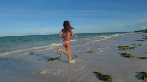 SLOW MOTION Running athletic thin girl in shallow water Vidéo 86998039