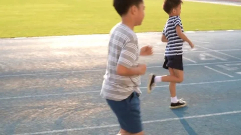 Slow motion running boy on blue track Stock Footage 72882829