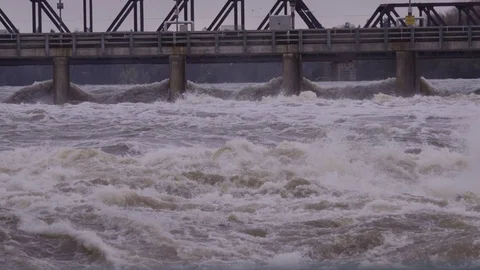 Slow motion rushing water through dam during flood Stock Footage 75512088
