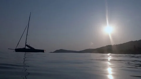 Slow motion of a sailboat at sunset on the beach Stock Footage 80584608
