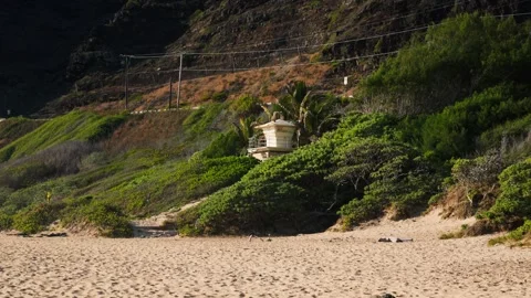 Slow Motion Sandy Beach with Lifeguard Tower and Mountain in Background Stock Footage 326014866