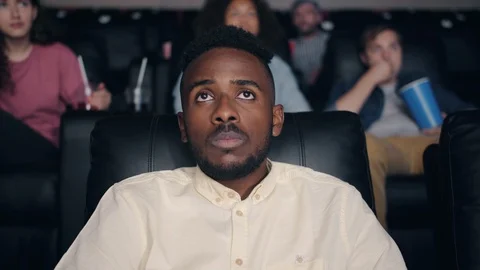 Slow motion of scared African American man watching horror film in cinema Stock-Footage 114769751